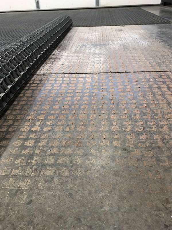 A close up of a concrete floor with a tire track in the background.