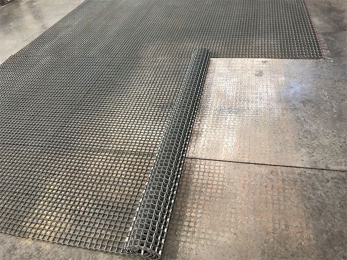 A piece of wire mesh is sitting on top of a concrete floor.