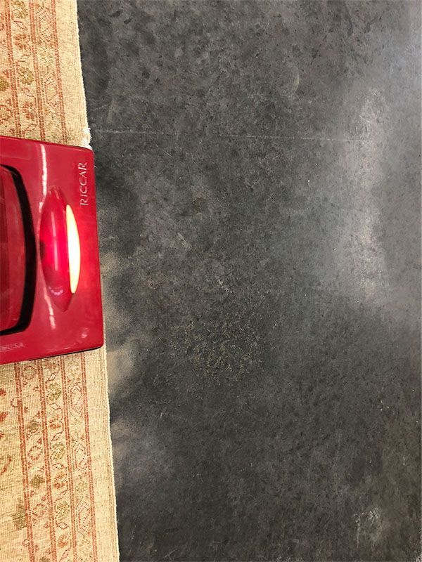 A red vacuum cleaner is sitting on a black surface.