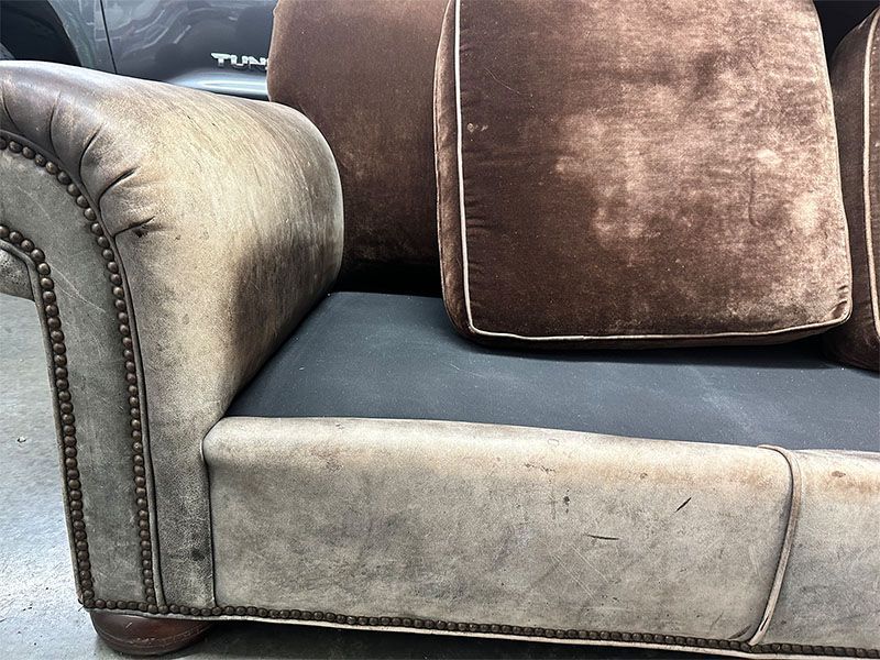 A brown leather couch with a black cushion