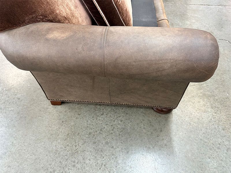 A brown leather chair is sitting on a concrete floor