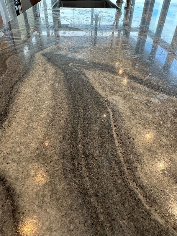 A close up of a marble counter top in a kitchen with a sink.