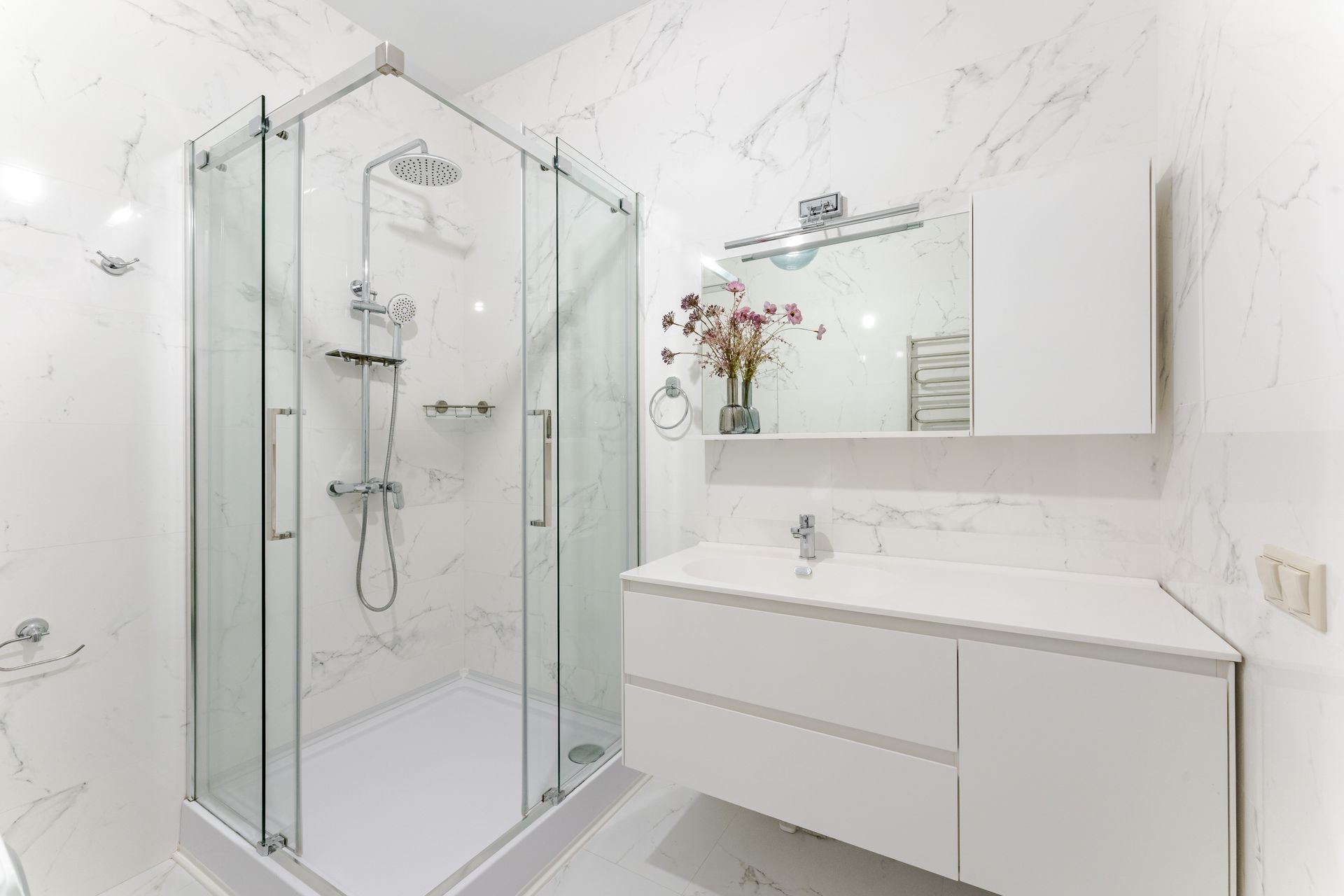 A bathroom with a walk in shower and a sink.