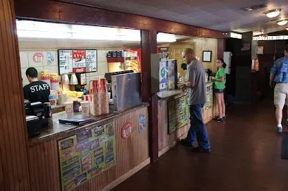 A man is standing at a counter in a restaurant.