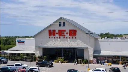 A h-e-b store with cars parked in front of it