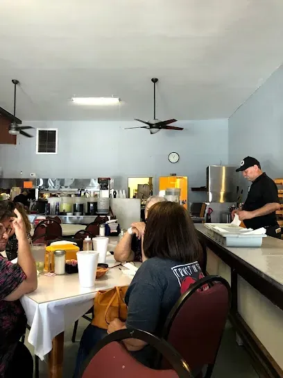 People sitting at tables in a restaurant with a woman wearing a shirt that says freedom