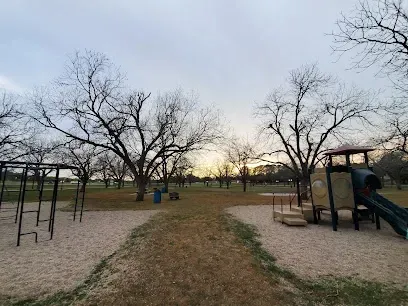 A playground in a park with a path leading to it.