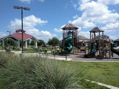 A park with a playground and a gazebo in the background