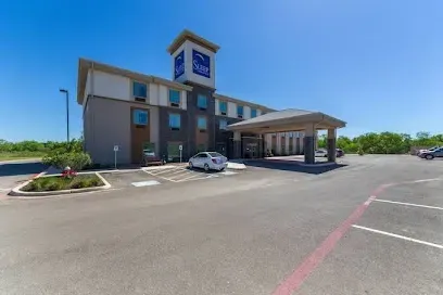 A large hotel with cars parked in front of it.