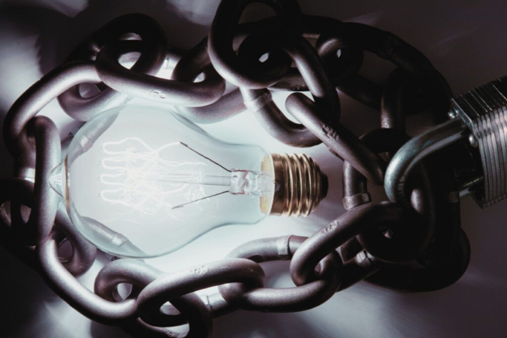 A light bulb is chained to a metal chain