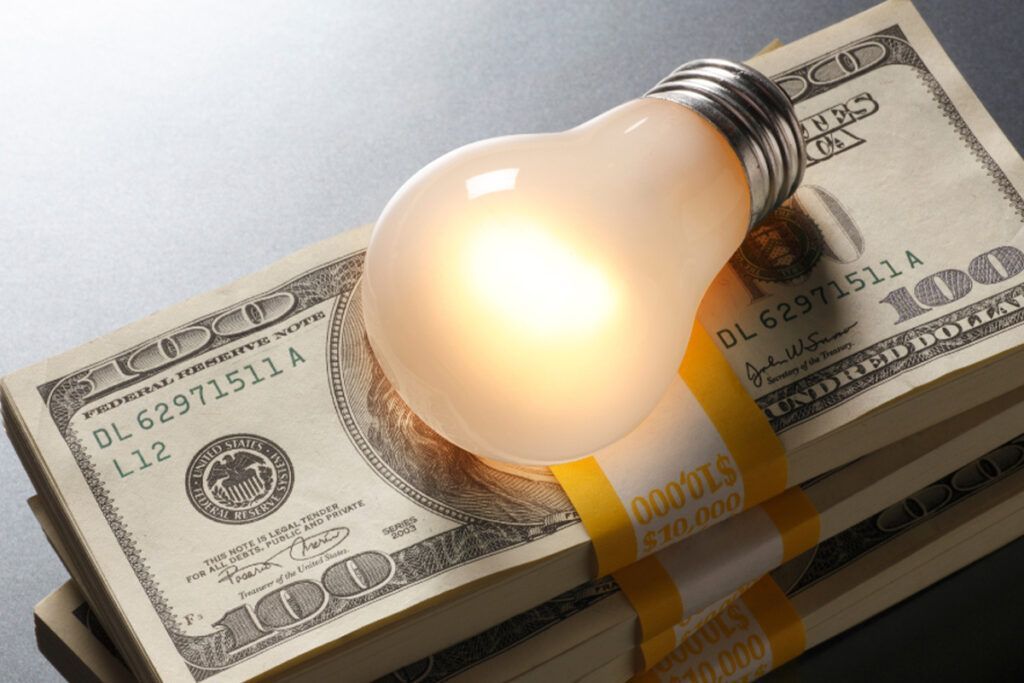A light bulb is sitting on top of a stack of 100 dollar bills