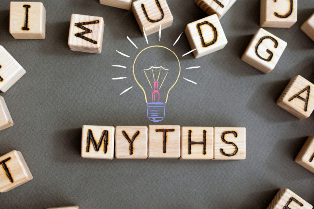 A light bulb is surrounded by wooden blocks that spell out the word myths.