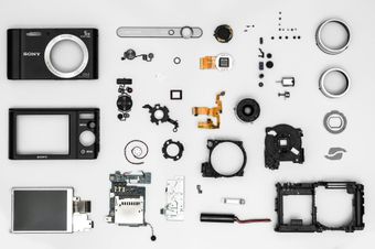 The parts of a camera are laid out on a white surface