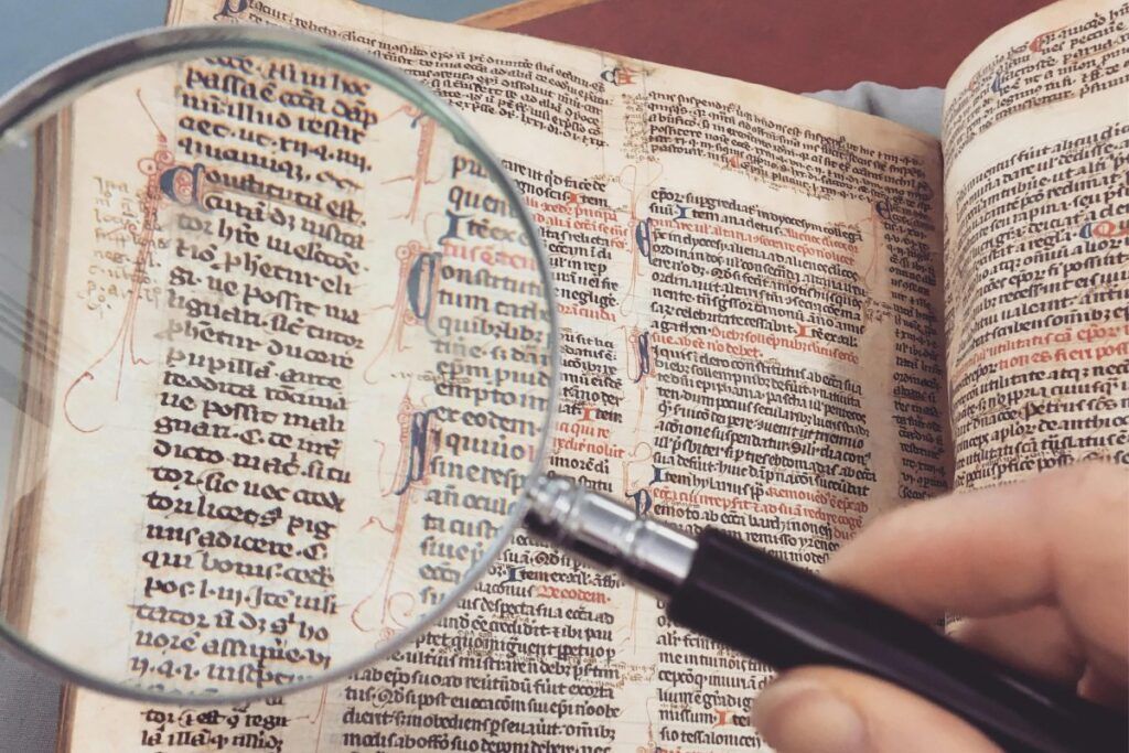 A person is reading a book with a magnifying glass