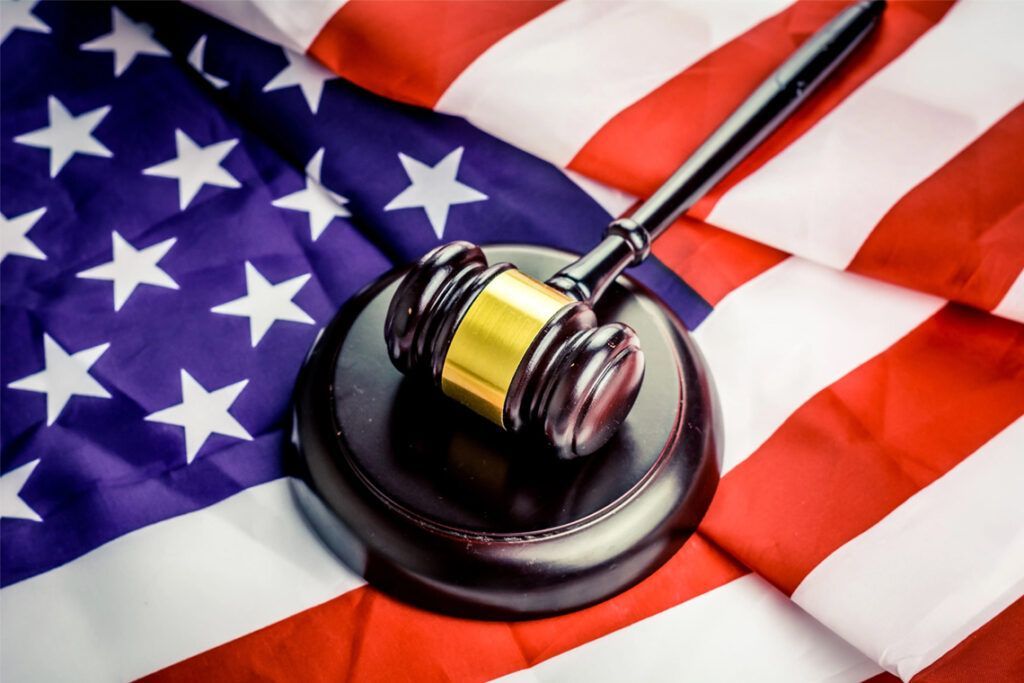 A judge 's gavel is sitting on top of an american flag.