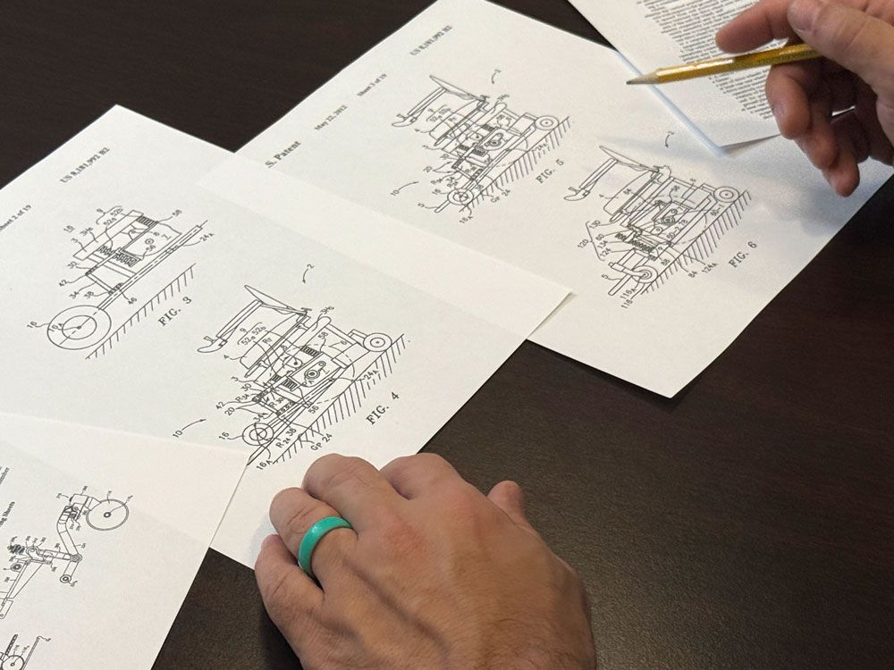 A person wearing a green ring is drawing on a sheet of paper.