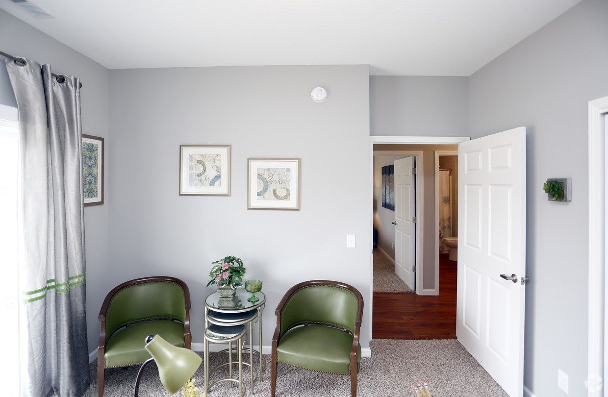 A living room with two green chairs and a table