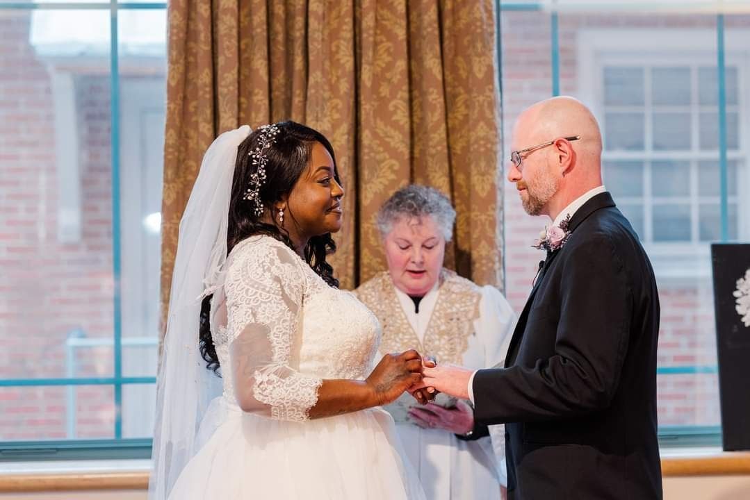 Bride and groom exchanging rings during a wedding ceremony with officiant nearby
