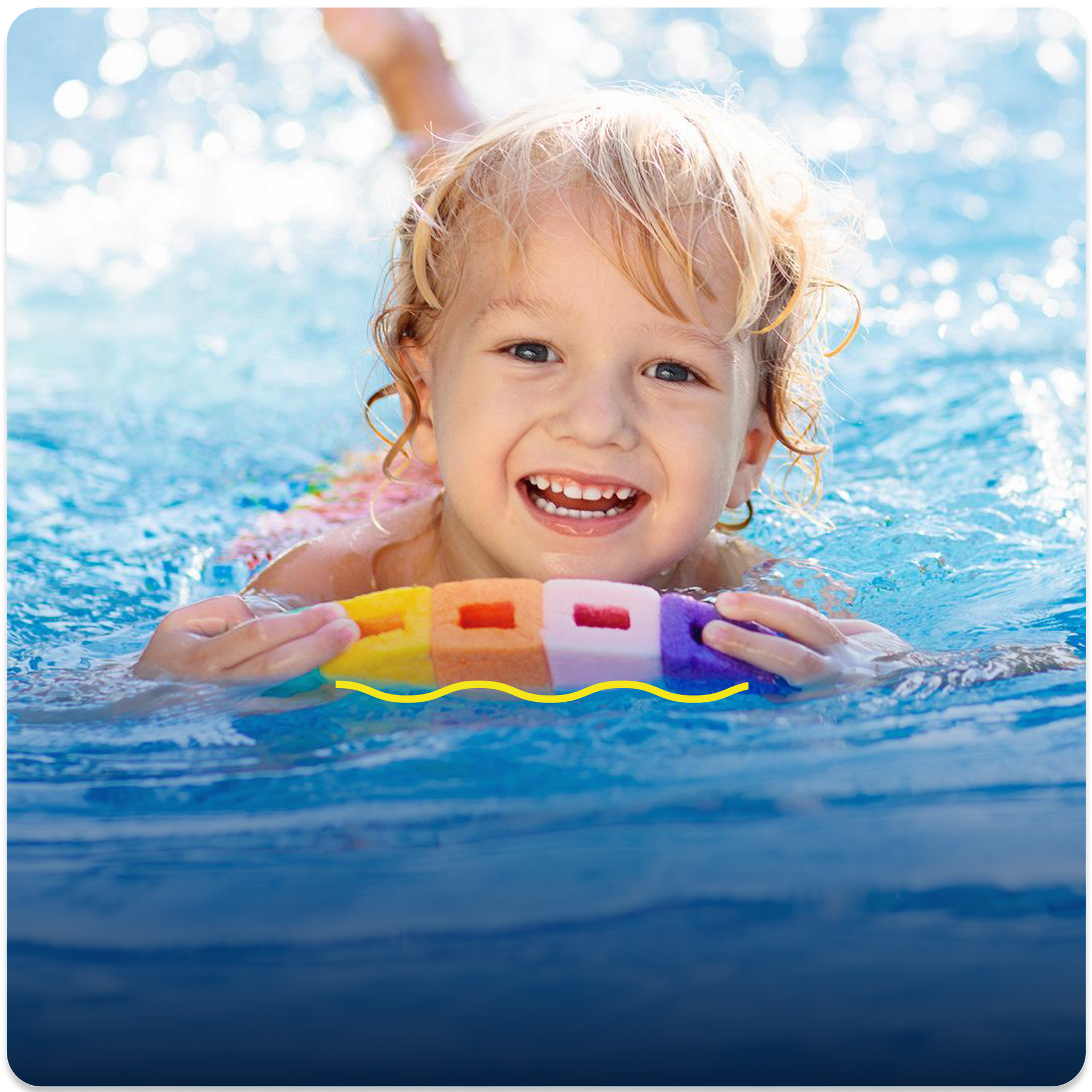 A little girl is swimming in a pool and smiling