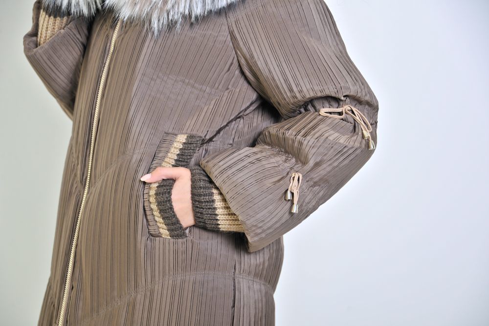 Donna che indossa un cappotto invernale marrone con collo di pelliccia e cappuccio foderato di pelliccia.