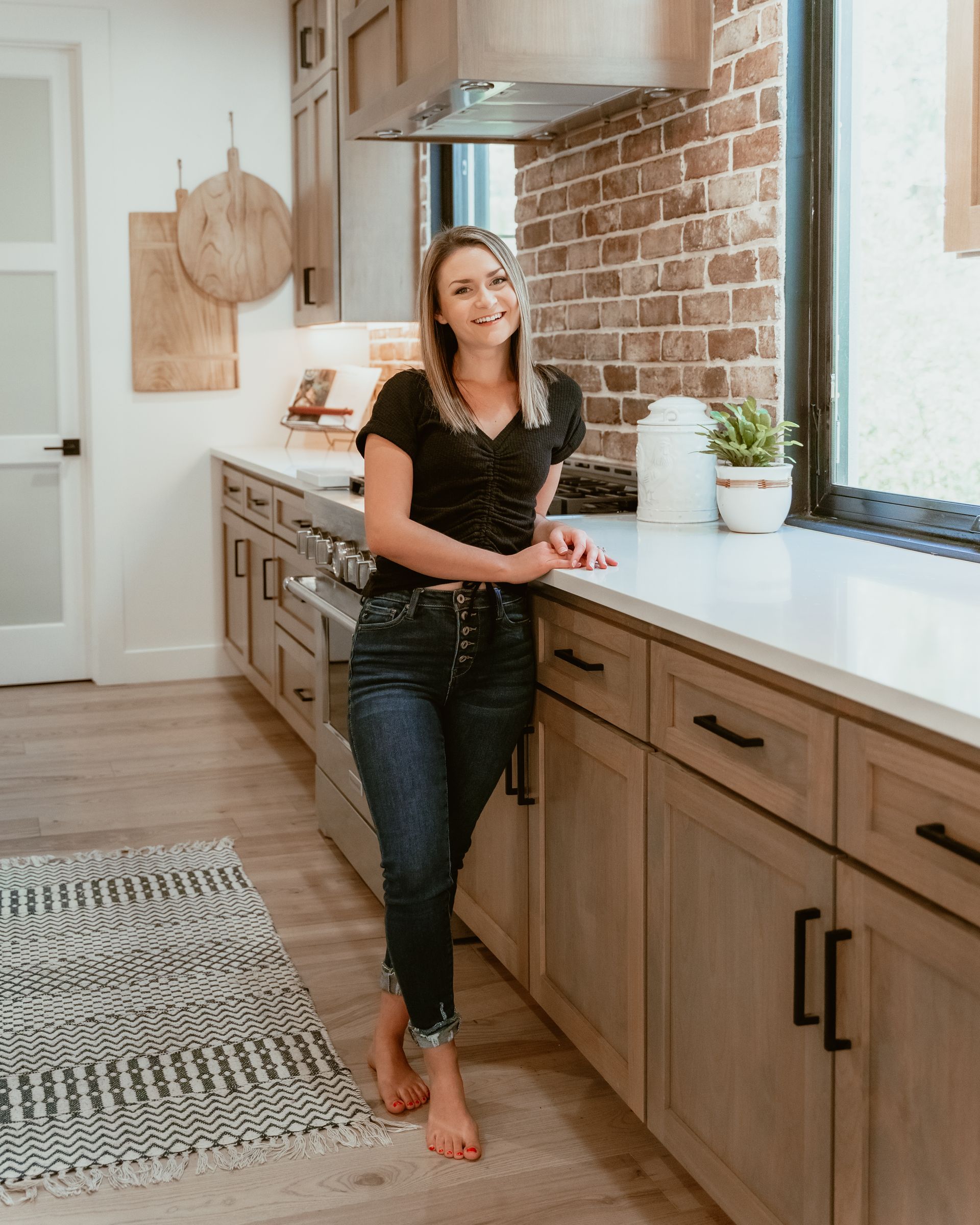 Bree is standing in a kitchen leaning against a counter.
