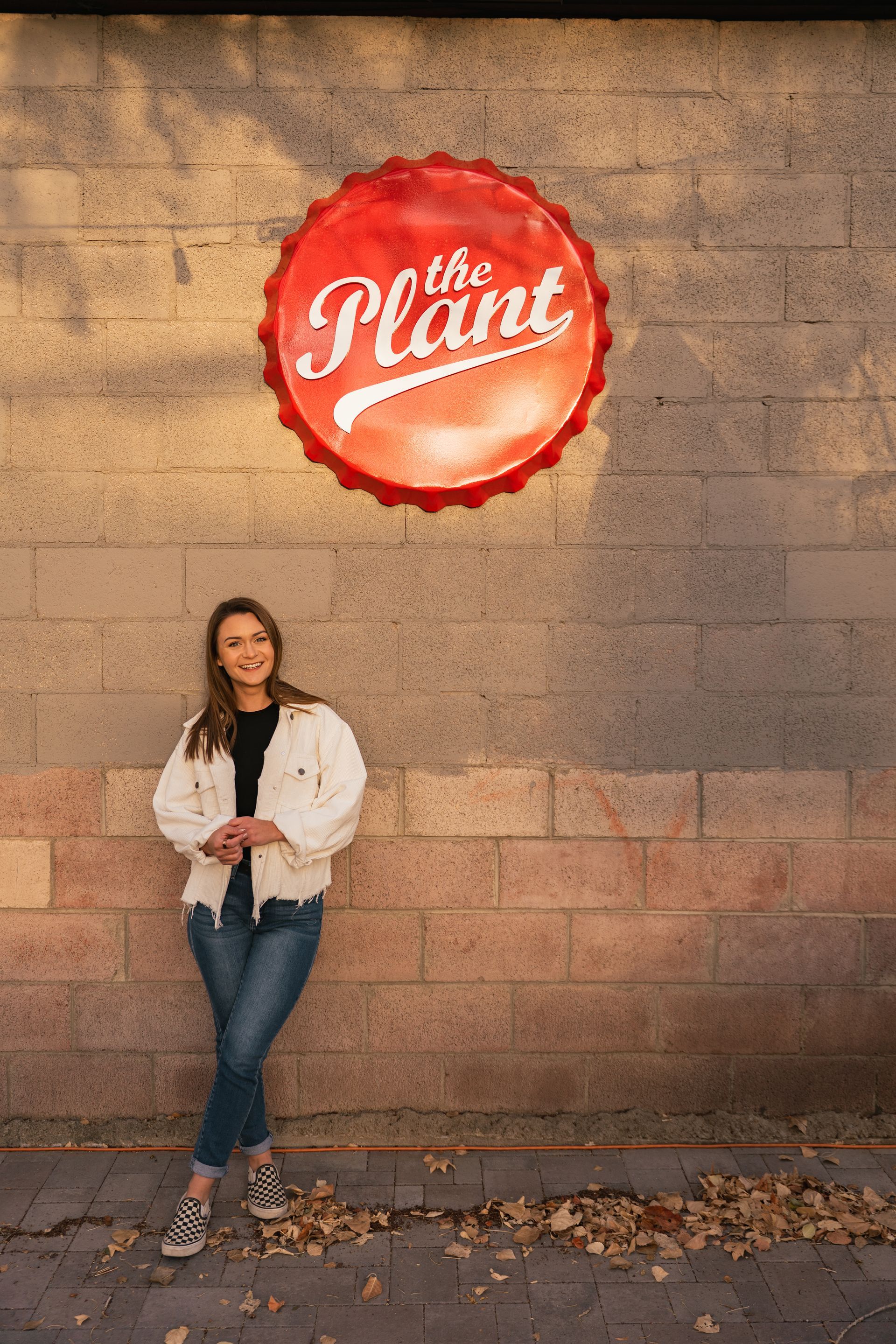 Bree is standing in front of a brick wall with a sign on it.