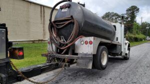 A black and white tank truck is parked on the side of the road.