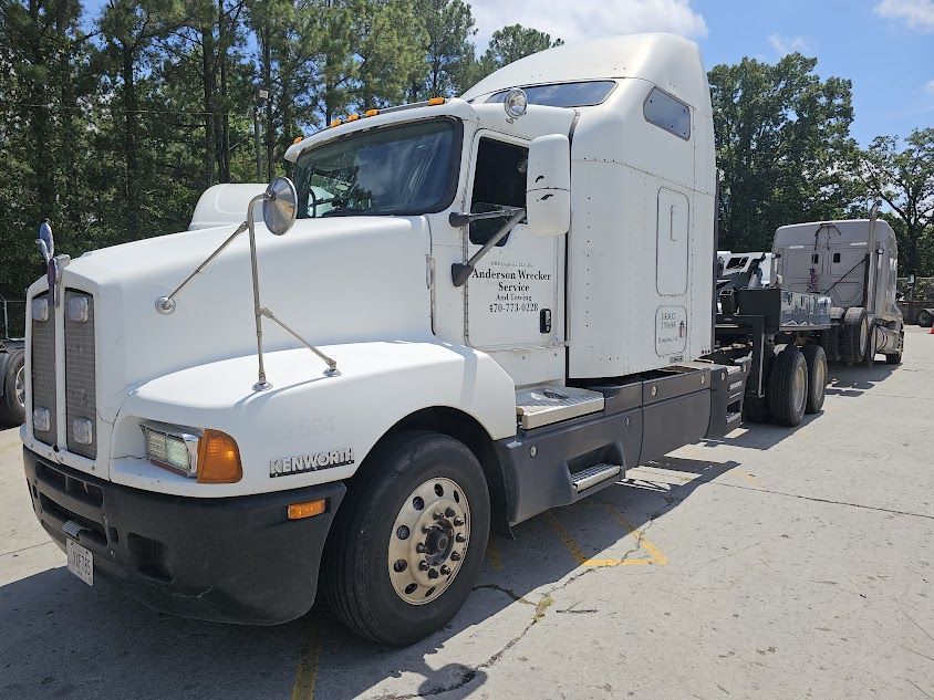 A white semi truck is parked in a parking lot