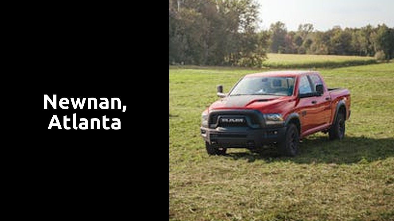 A red truck is parked in a grassy field.