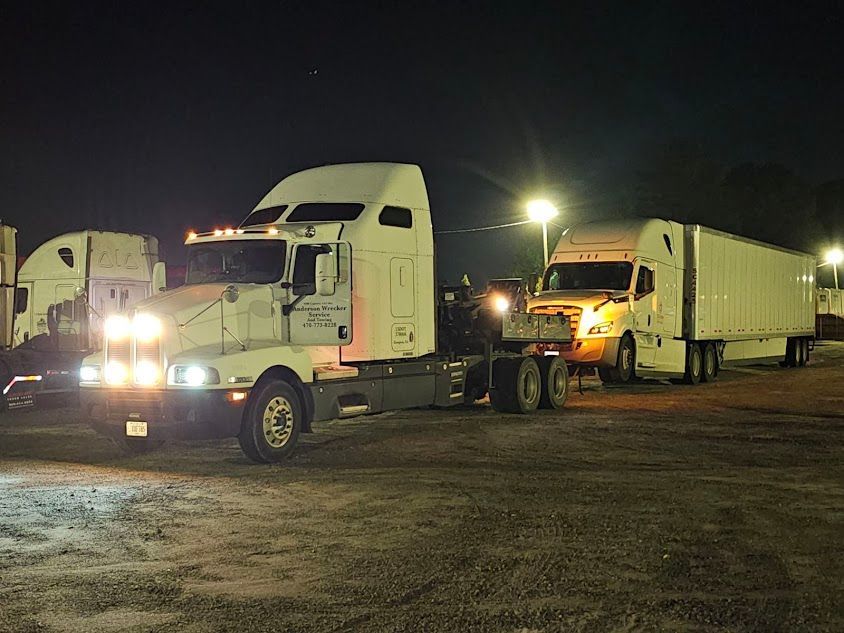 Two semi trucks in a parking lot at night. Two semi trucks in a parking lot at night.