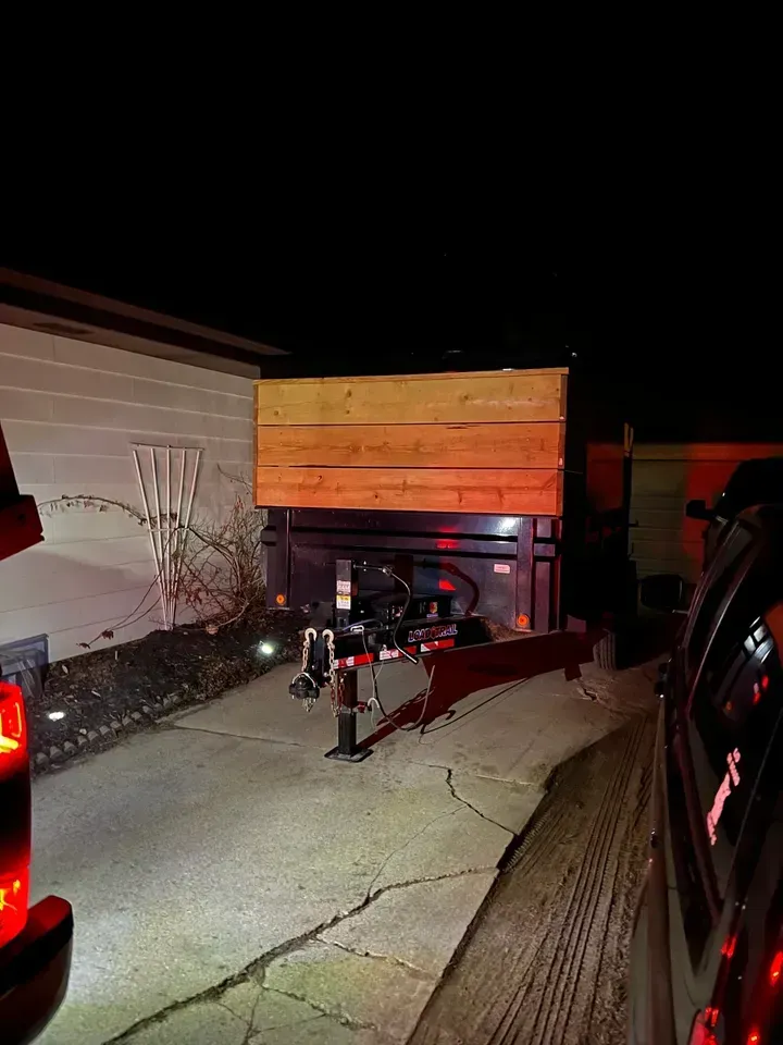 Nighttime dumpster rental drop-off on residential driveway by Junk Team