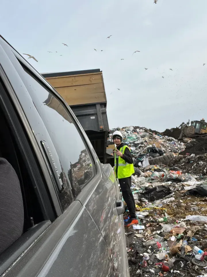 Junk Team worker unloading debris at landfill during junk removal service