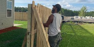 Man Installing Wood Fence — Hinesville, GA — Hinesville Fence EBG LLC