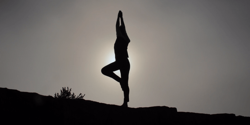 silhouette of person doing tree pose