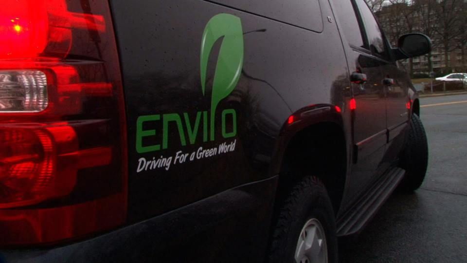A man and a woman are loading luggage into the back of a car.