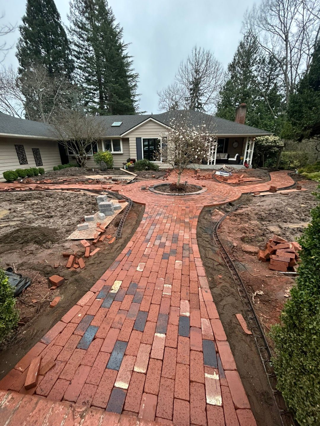 Patio with wicker furniture, gazebo, and potted flowers. White house in background.