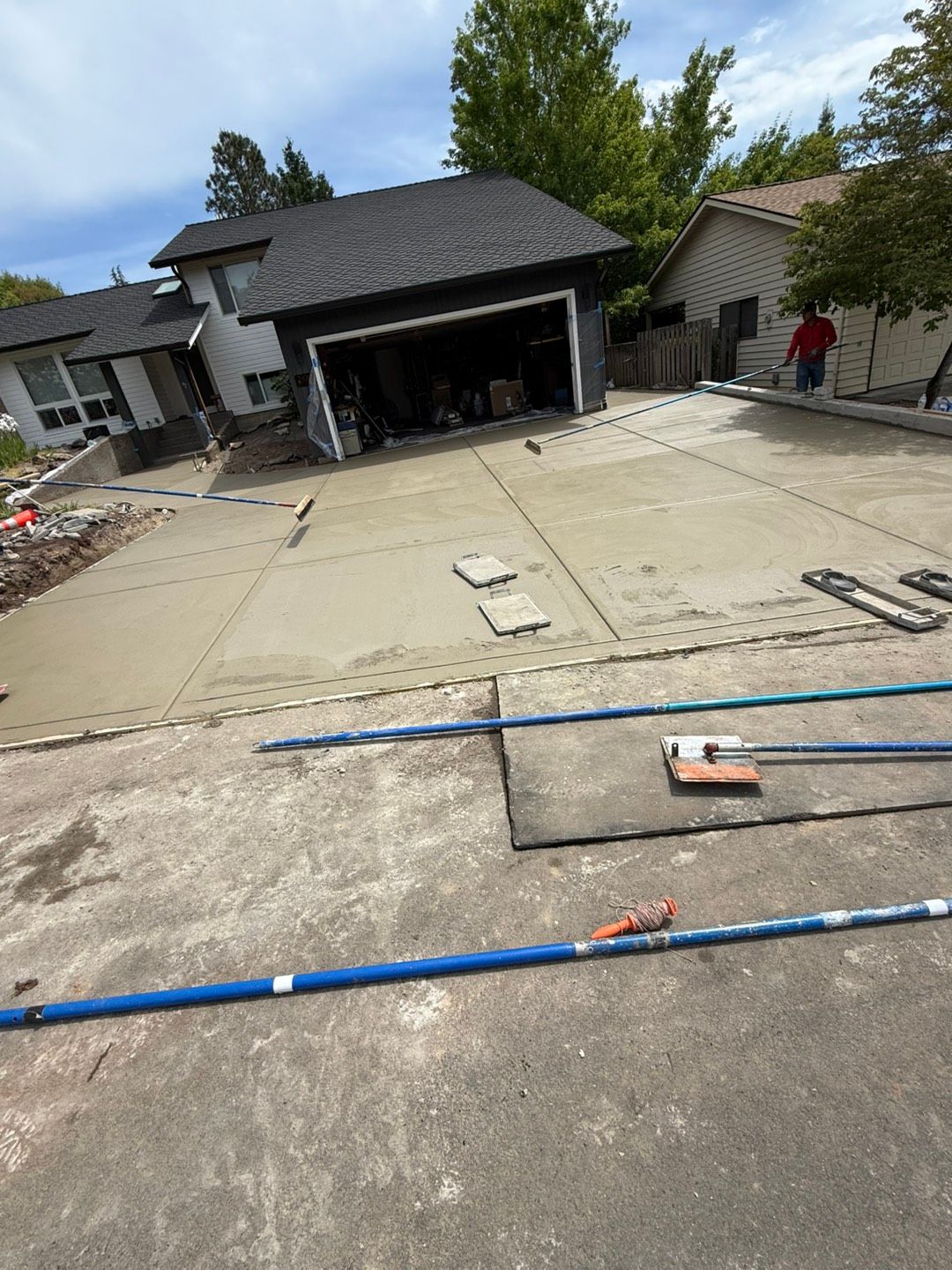 Person smoothing wet concrete with a tool; construction site, close-up. Person smoothing wet concrete with a tool; construction site, close-up.
