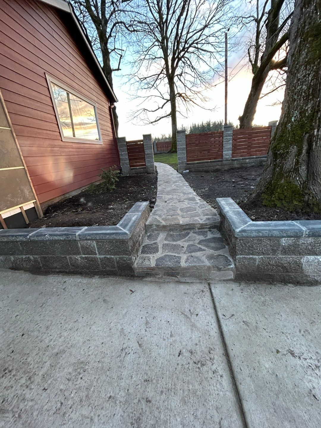 Stone wall with irregular, light-brown granite blocks and dark mortar.