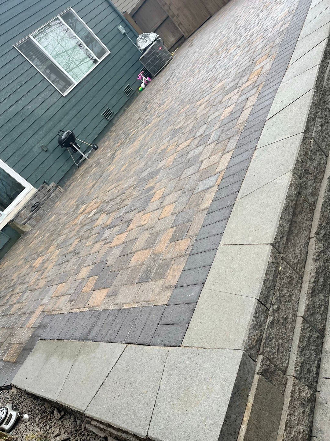 Stone retaining wall with plants, bordering a paved path. Stone retaining wall with plants, bordering a paved path.