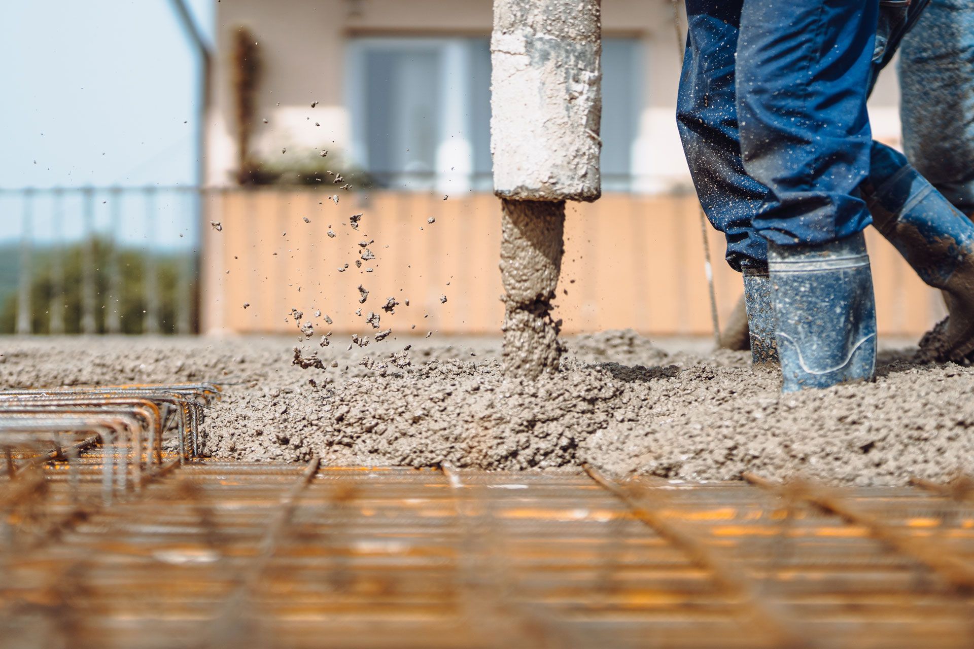 Concrete being poured onto rebar grid at a construction site. Concrete being poured onto rebar grid at a construction site.