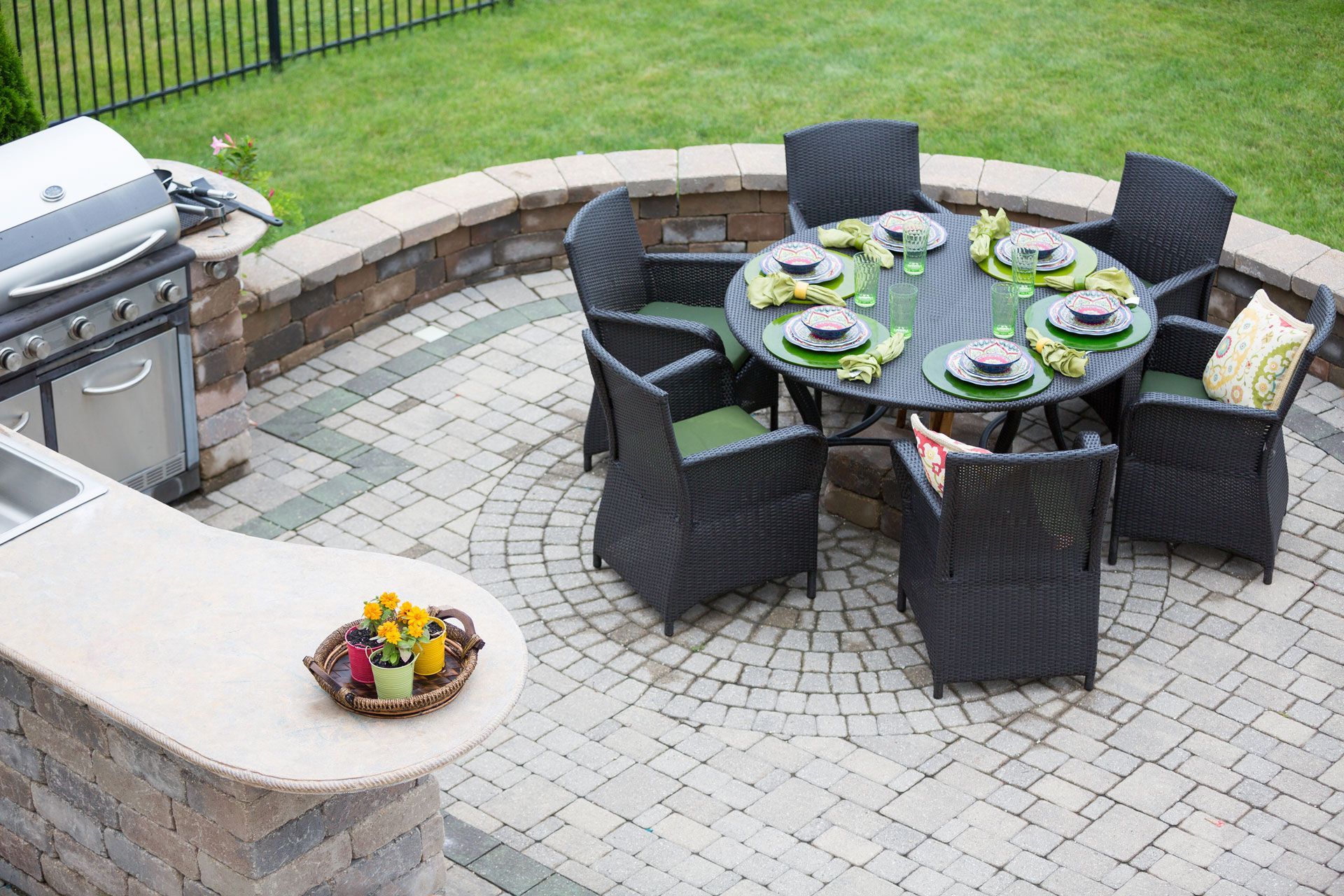 Patio with round table set for dining, grill, and stone pavers. Patio with round table set for dining, grill, and stone pavers.