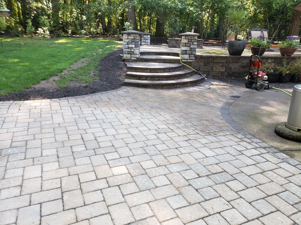 Brick walkway with herringbone pattern next to a patch of green grass.