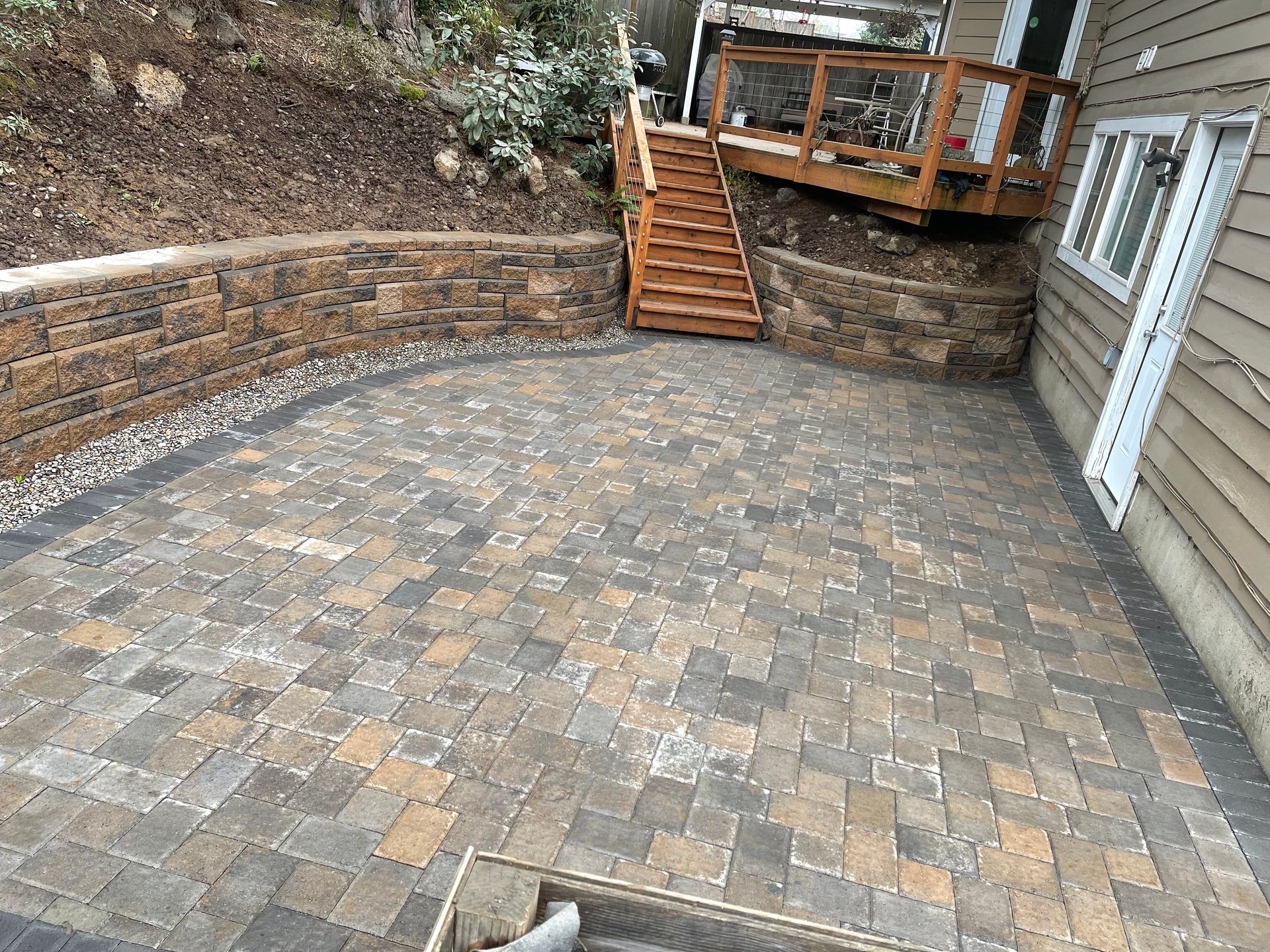 Stone retaining wall with a bed of flowers, in a grassy setting. Stone retaining wall with a bed of flowers, in a grassy setting.