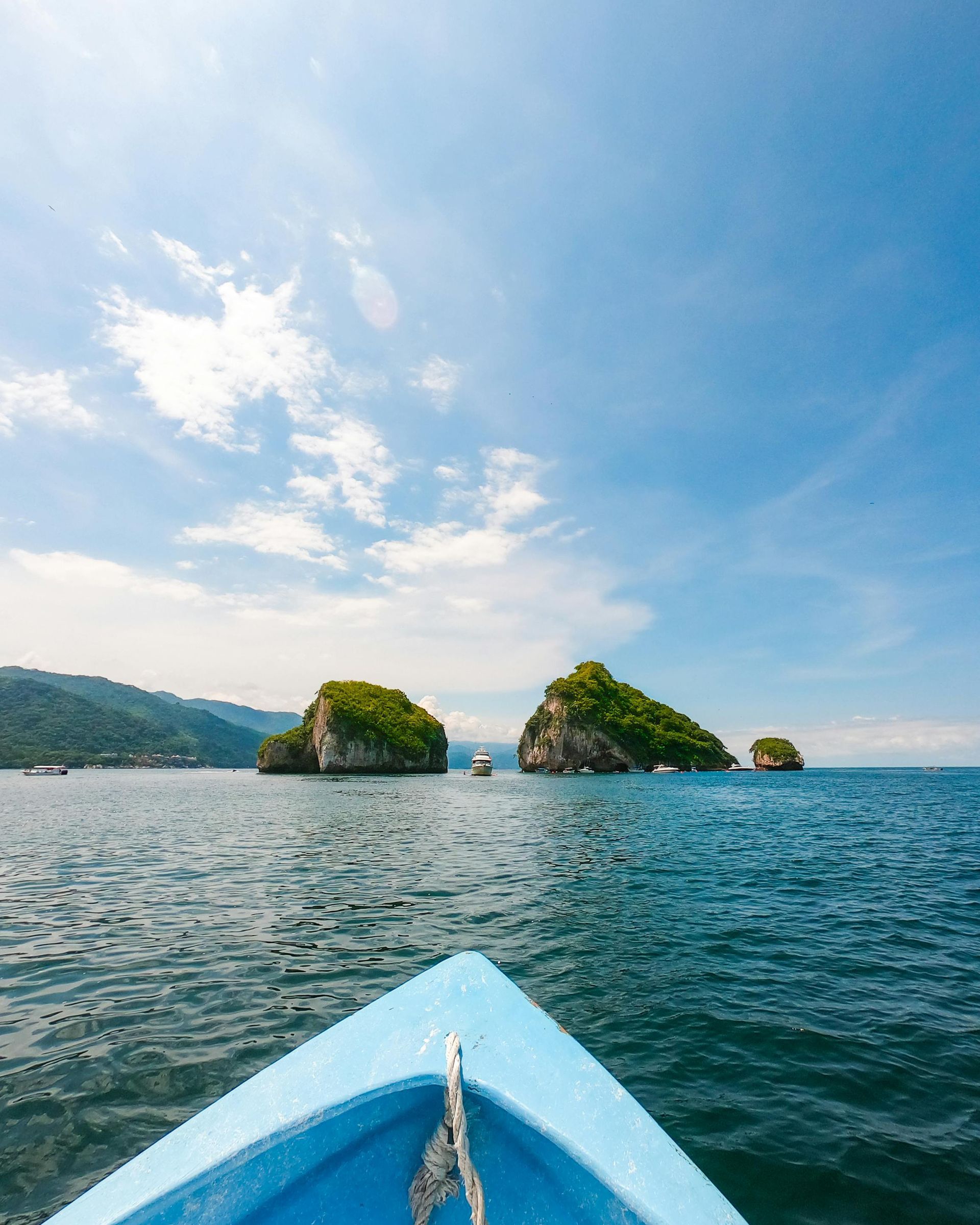 A boat is floating on a body of water with islands in the background