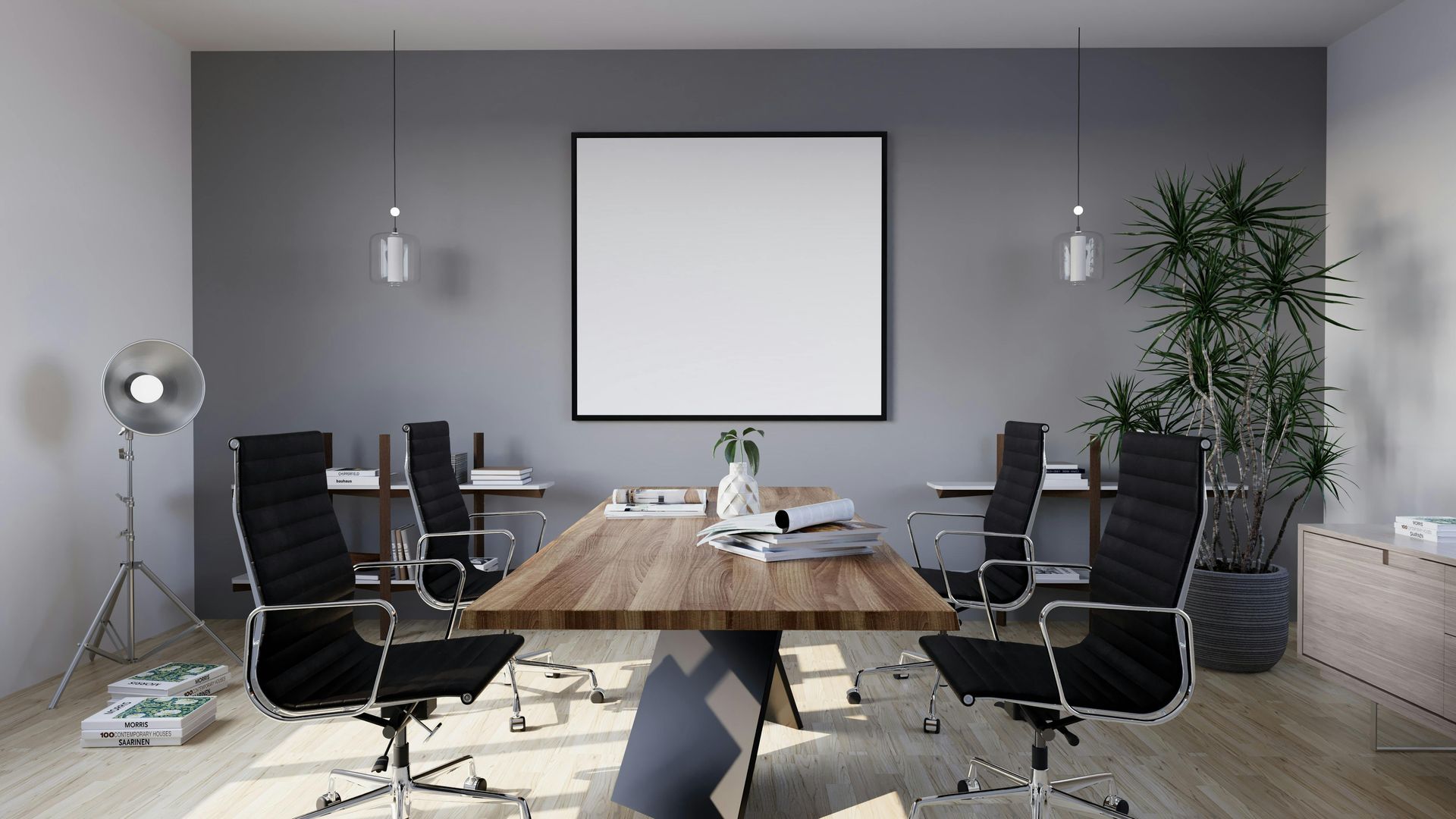Modern conference room with a long wooden table, black chairs, wall screen, and potted plant