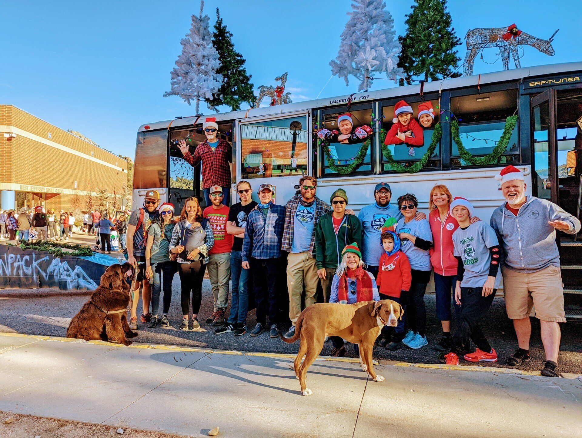 A group of people are posing for a picture in front of a bus.