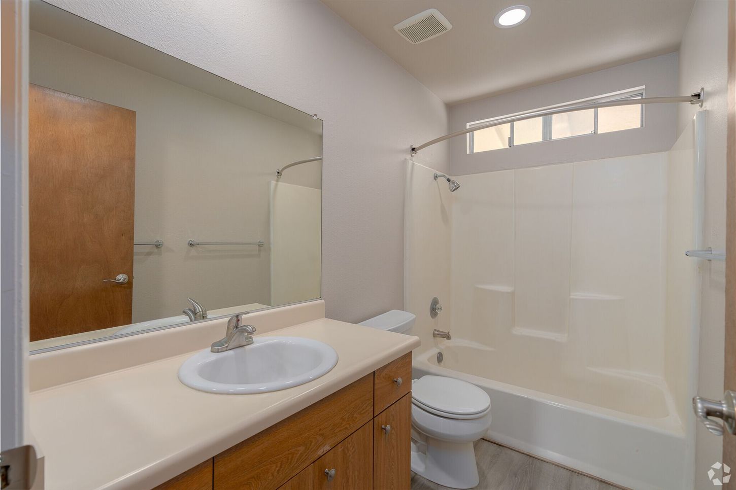 A bathroom with a sink , toilet , tub and mirror.