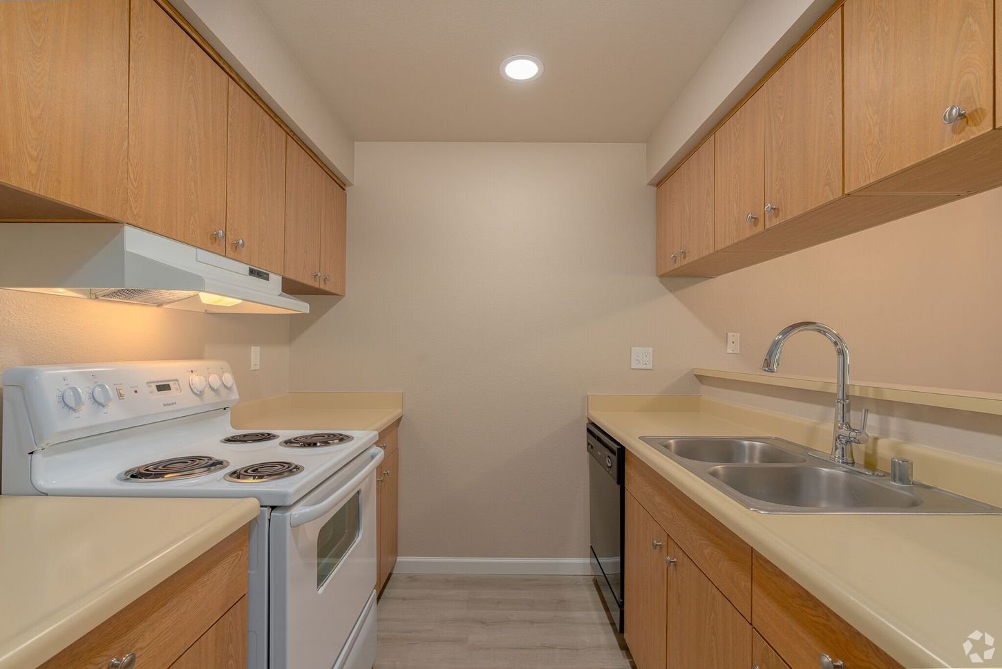 A kitchen with a stove , sink , and dishwasher.