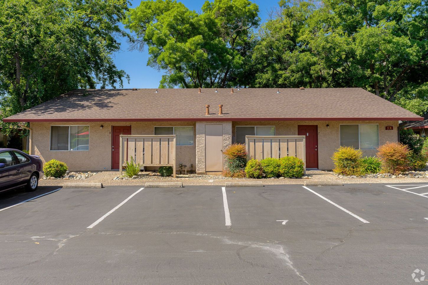 A car is parked in front of a small apartment building.