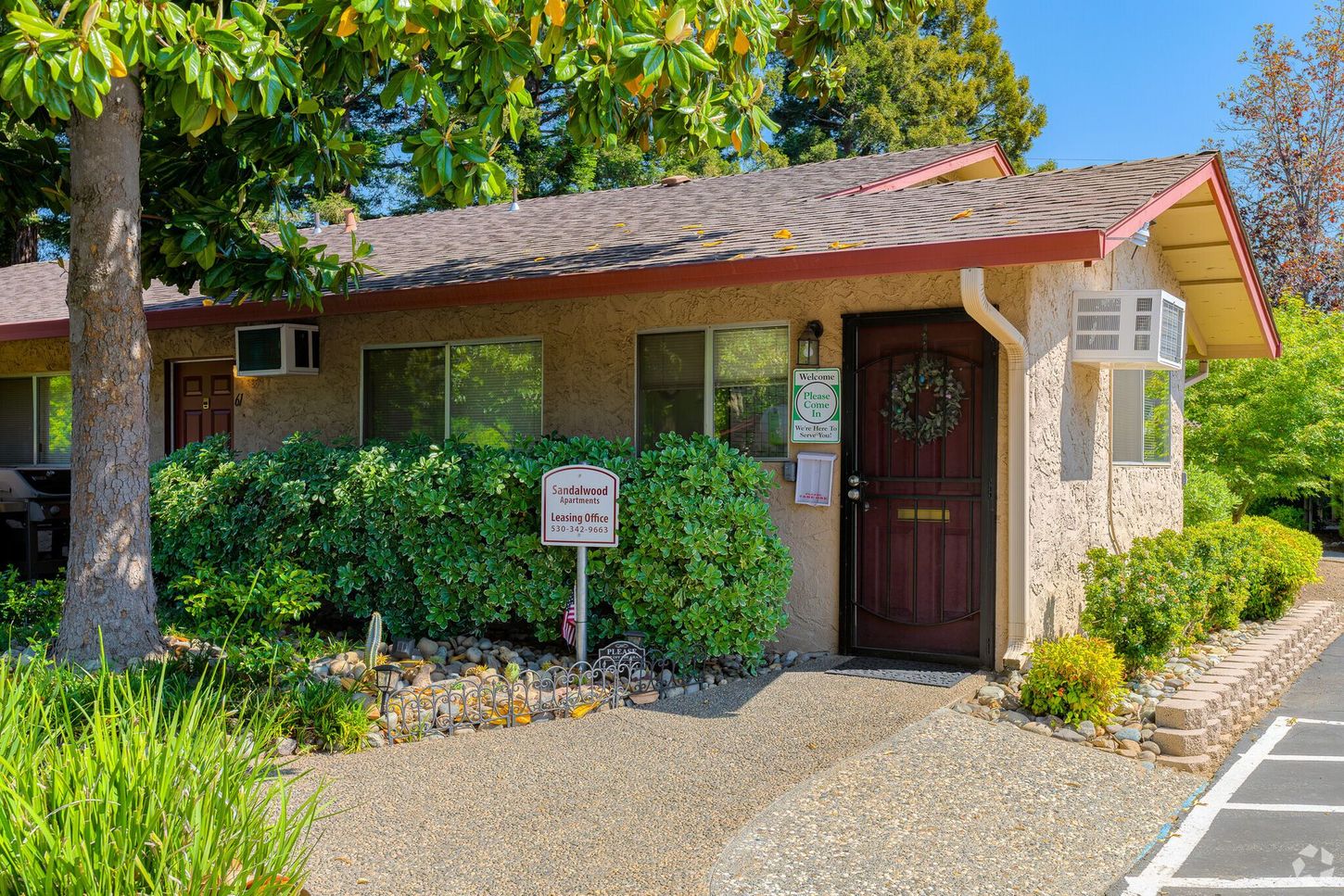 A small house with a red door and a sign in front of it